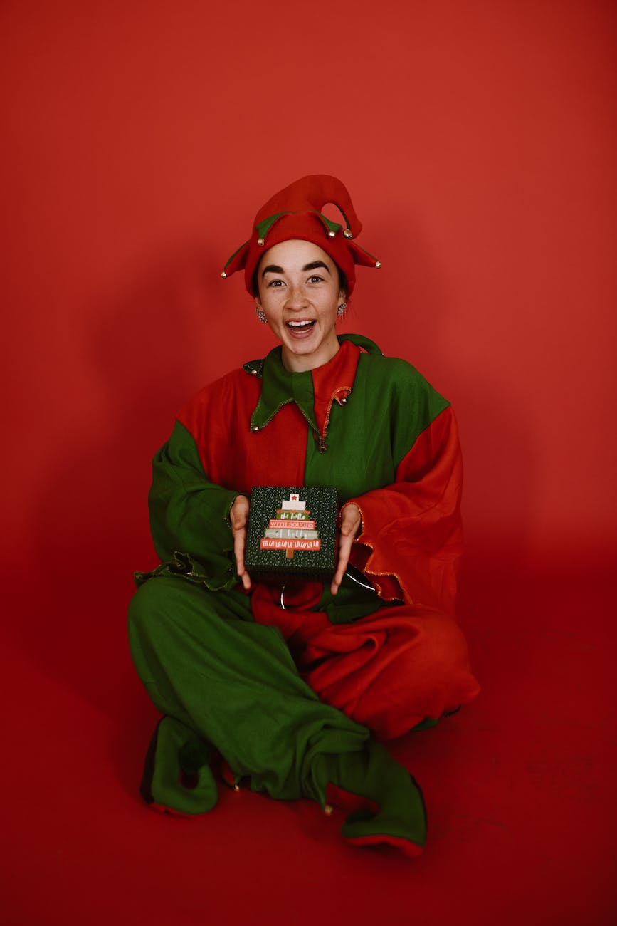 a woman in elf costume sitting holding a gift