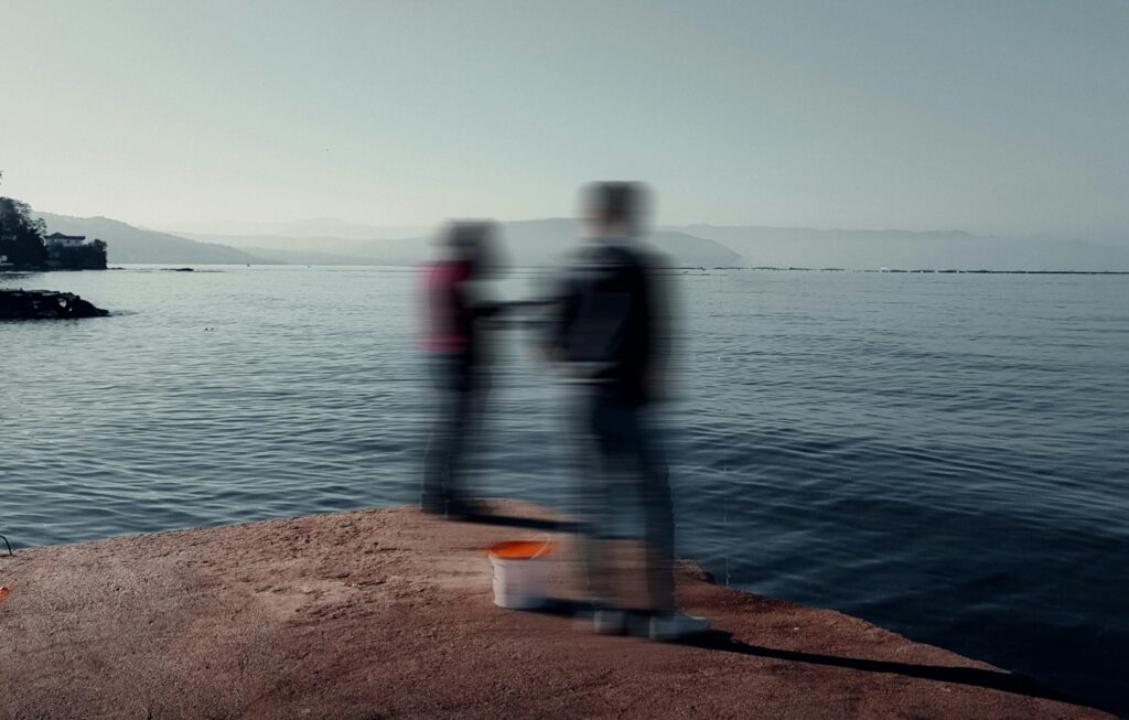 2 people on a pier by the ocean