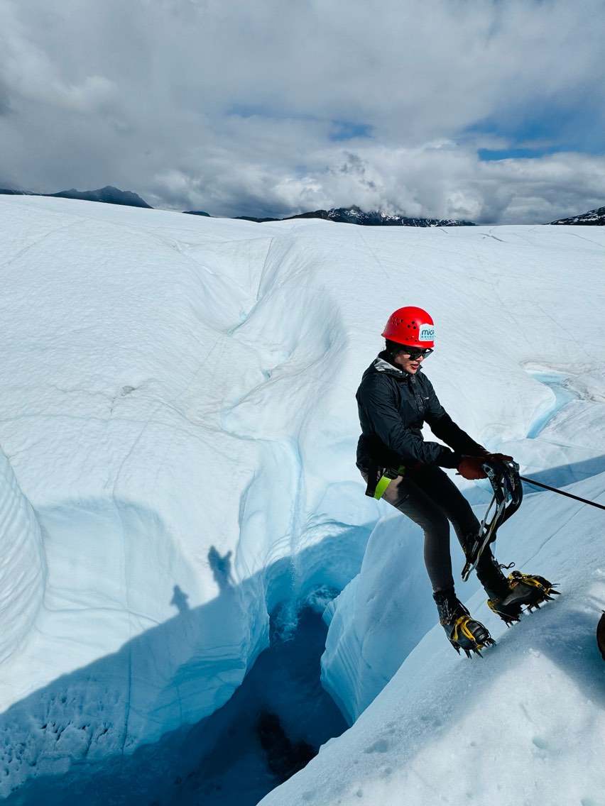 person spelunking on glacier
