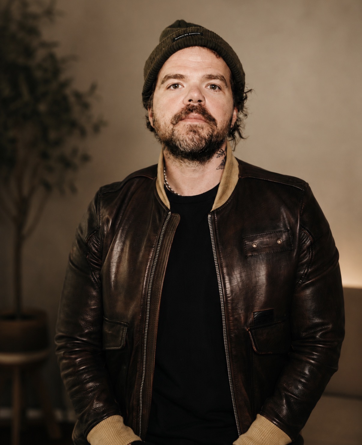 man in leather jacket and hat