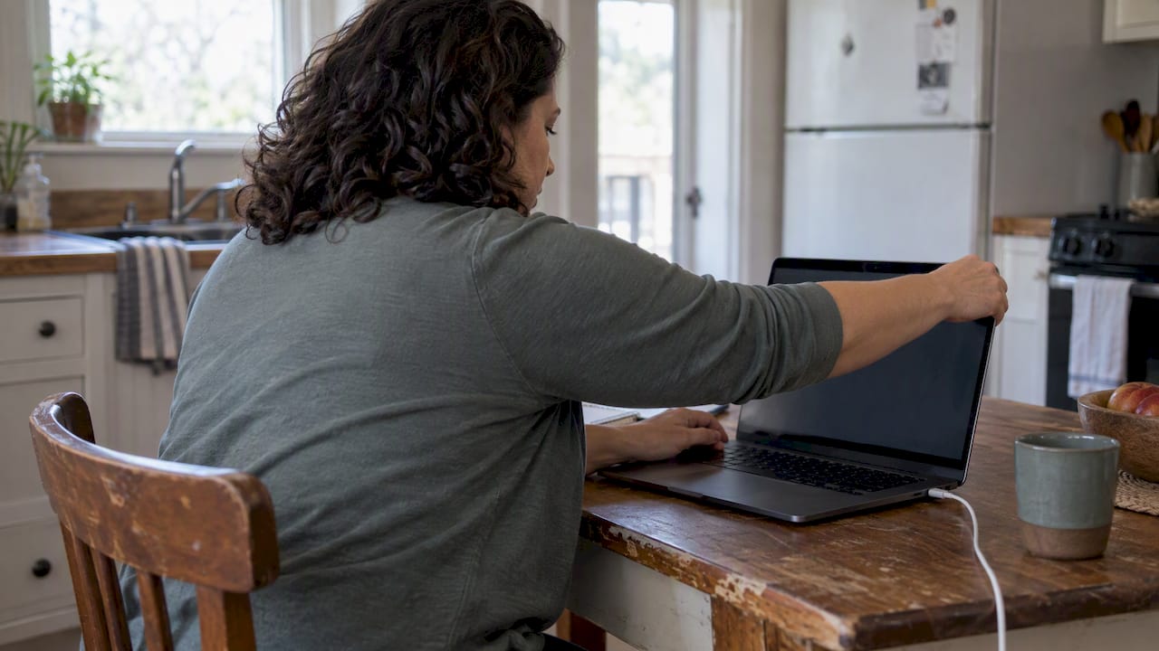 Woman adjusting telehealth assessment setup at home